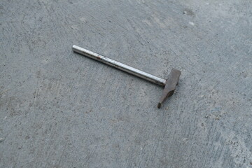 Photo of an iron hammer on the ground