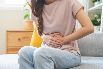 Flatulence asian young woman intolerance hand in stomach ache, suffer from food poisoning,...