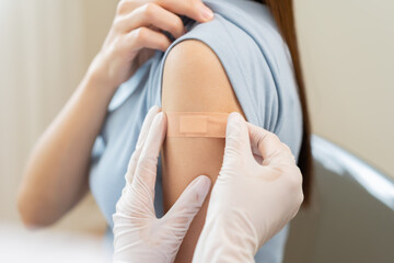 Vaccination coronavirus, hand of doctor apply plaster, bandage after doctor giving vaccine, injection dose on arm patient, immunization disease prevention against flu pandemic influenza, health care.