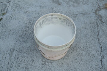 Photo of an empty white bucket on the ground