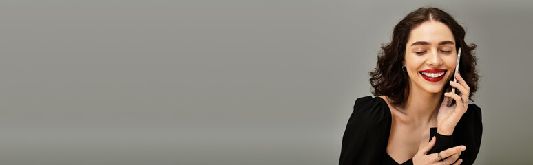 Fototapeta premium Confident young woman smiles with red lips and braces on a neutral background