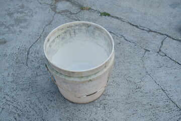 Photo of an empty white bucket on the ground