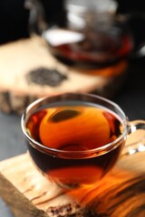 Aromatic black tea in cup on table, closeup