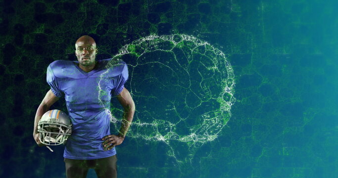 Image of digital brain spinning over male american football player holding helmet - Powered by Adobe