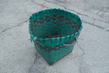 photo of a green trash can on the ground