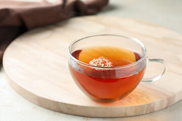 Aromatic tea in cup on light table, closeup