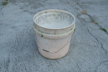 Photo of an empty white bucket on the ground