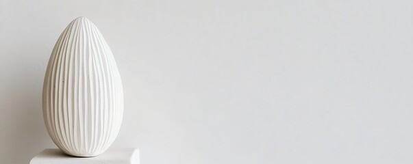 Textured white egg sculpture on pedestal with minimalist white background and copy space