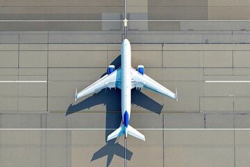 Large passenger airplane seen from above on runway with geometric pattern, creative graphic style, concrete background, concept of travel. Ai generative