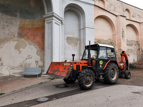 Prague, Czech Republic - March 26, 2025: Red zetor tractor parked in front of a weathered wall in prague vojan gardens