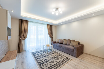 Modern Living Room Interior With Sofa, Curtains, and Decorative Rug. Bright and contemporary living room featuring a cozy sofa, floor-length curtains, patterned rug, and elegant lighting. Scandinavian
