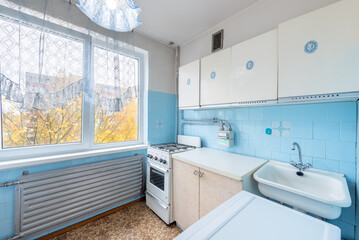 Retro Styled Home Kitchen With Light Blue Tiles and Vintage Furniture Setup White Cabinets