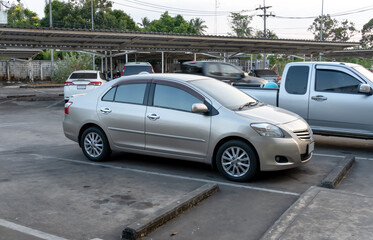 Single silver or gray sports sedan car with right side view parking at open area parking lot of department store in a city.