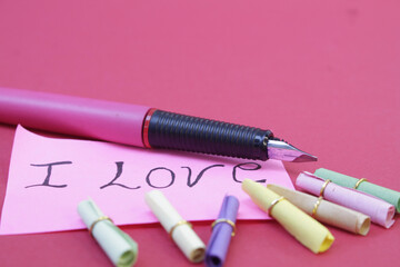 Mensaje de amor escrito con un Pluma para cartas, colocados sobre un fondo color rosado, ideal para...