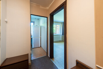 Hallway View Inside a Home With Doors Leading to Rooms and Kitchen