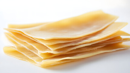 Neatly arranged lasagna sheets on a white, minimal background, slightly overlapping to show their...