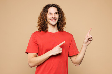 Young smiling happy Caucasian man he wear red t-shirt casual clothes point index finger aside on...