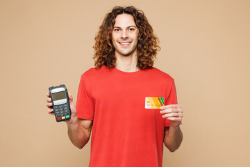 Young man wear red t-shirt casual clothes hold wireless modern bank payment terminal to process...