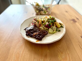 Homemade beef with tomato paste and salad on wooden table