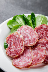 Dry-cured sausage salami appetizer dish fresh gourmet food background on the table rustic food top view copy space