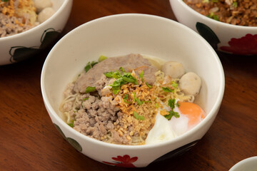 Close-up culinary delight noodle bowl with meat and egg in cozy atmosphere