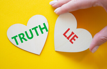 Truth or Lie symbol. Concept word Truth or Lie on wooden hearts. Businessman hand. Beautiful yellow...
