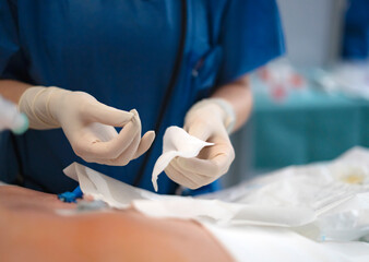 Surgeon preparing gauze for wound dressing during surgery
