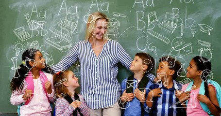 In school, teacher with diverse children smiling at animation doodles on chalkboard
