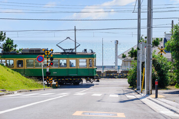 Naklejka premium 海沿いの踏切を通過する江ノ電、鎌倉、七里ヶ浜