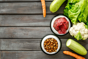 Bowls with healthy pet food and ingredients, top view