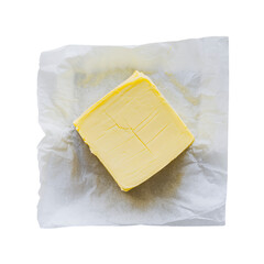 A square of creamy, pale yellow butter sits on parchment paper, ready for baking or spreading, a simple yet elegant still life.