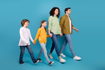 Fototapeta premium Happy family walking together against a blue background showcasing love and unity