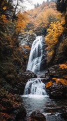 Obraz premium Majestic autumn waterfall amidst vibrant foliage in serene forest
