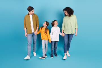Obraz premium Happy family spending quality time together walking and holding hands on a blue background