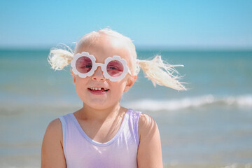little girl with sun glasses on the beach