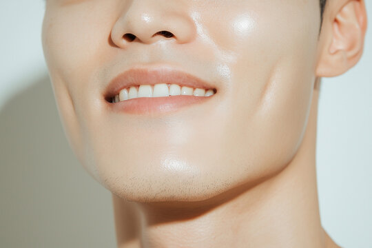 handsome east asian korean man strong jaw glass skin no pores smiling with white teeth and perfect face with dimples cosmetic surgery and dentistry jawline 