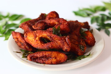 Vietnam pearl spot fish marinated with aromatic spices and fried to golden perfection, garnished with fresh curry leaves