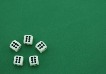 Five white dice arranged on a green surface showing various numb