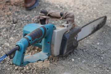 A chainsaw machine is kept on the ground in close up