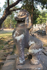 Stone creature sculpture with open mouth and detailed form in outdoor temple setting Fierce...