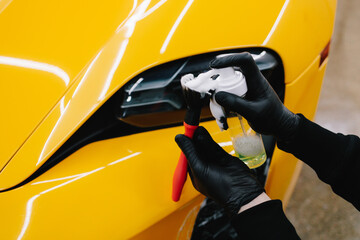 Detailing car headlights cleaning with foam and soft brush. Process of detailing sports car...