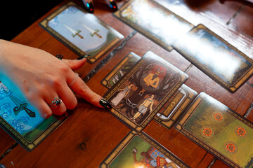 Fortune teller reading tarot cards on wooden table