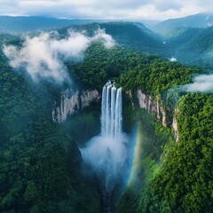 Fototapeta premium Aerial View of a Majestic Waterfall Cascading Through a Lush Green Forest with Mist and a Rainbow, Creating a Breathtaking Natural Spectacle