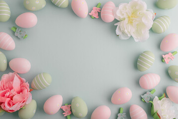 Easter eggs and spring flowers on pastel background. Top view