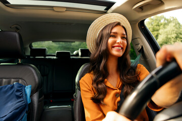 Journey and transportation concept. Smiling young woman driving car, going on trip alone, backpack...