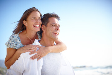Beach, piggyback and couple with smile, outdoor and holiday for romance, date and happy in...