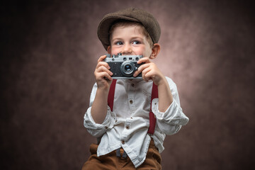 Boy Photographer with Retro Camera making picture against vintage background