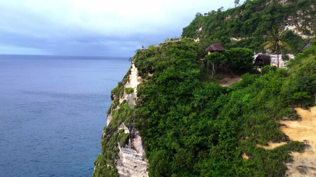 Aerial drone view of Nusa Penida Rumah Pohon Tree House, Bali. View of the cliff and turquoise water. Indonesia
