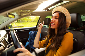 Woman traveler travelling by car and listening music, enjoying car trip alone. Travel, tourism and...