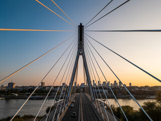 modern metal cable bridge over Vistula river at sunset, contemporary geometric architecture, cable-stayed bridge at city skyline, symmetry and architectural urban contrast, Warsaw